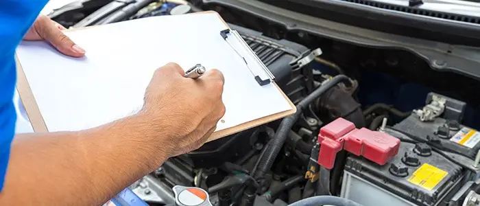 Prancheta anotando detalhes de um motor de carro