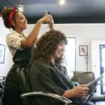 Cabeleireira cortando o cabelo de mulher